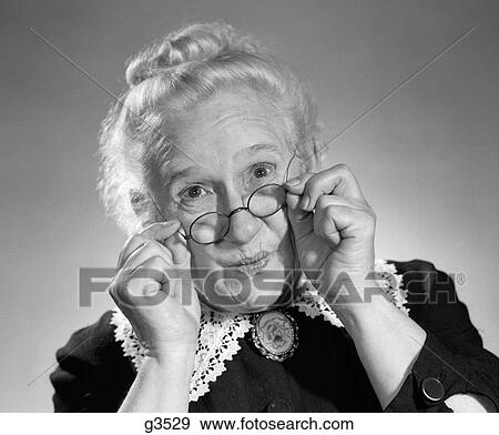 Stock Photo - 1950S Portrait Of Smiling Old Lady Holding Her Antique Wire Frame Glasses. Fotosearch