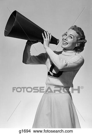 1950S Portrait Smiling Teenage Girl Cheerleader In Sweater And Long Skirt Cheering Through Megaphone Looking At Camera View Large Photo Image Picture - 1950S Portrait Smiling Teenage Girl Cheerleader In Sweater And Long Skirt Cheering Through Megaphone Looking At Camera. Fotosearch