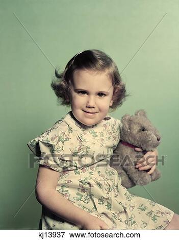 1950S Portrait Smiling Toddler Girl Holding Stuffed Animal Toy View Large Photo Image Stock Photo - 1950S Portrait Smiling Toddler Girl Holding Stuffed Animal Toy . Fotosearch