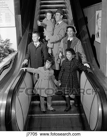 1950S Smiling Family Of 6 In Winter Coats Going Down Store Escalator View Large Photo Image Stock Photography - 1950S Smiling Family Of 6 In Winter Coats Going Down Store Escalator . Fotosearch