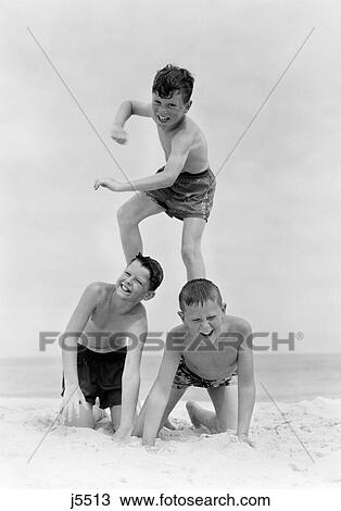 1950S Three Boys In Bathing Suits Form A Pyramid In The Sand On The Beach View Large Photo Image Stock Image - 1950S Three Boys In Bathing Suits Form A Pyramid In The Sand On The Beach . Fotosearch