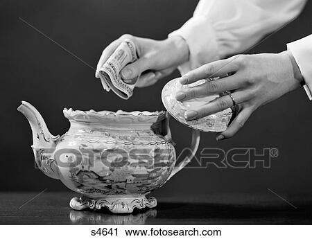 1950S Woman'S Hands Putting Wad Of Cash In Teapot View Large Photo Image Stock Image - 1950S Woman'S Hands Putting Wad Of Cash In Teapot. Fotosearch