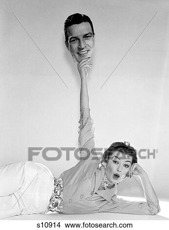 1960S 1950S Woman Holding Up Picture Of Man'S Head Like A Trophy In Triumph Looking At Camera View Large Photo Image Picture - 1960S 1950S Woman Holding Up Picture Of Man'S Head Like A Trophy In Triumph Looking At Camera . Fotosearch