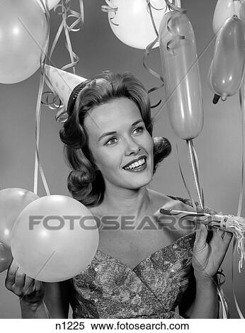 1960S 1950S Woman In Party Dress Smiling Holding Balloon And Noise Maker View Large Photo Image Stock Photography - 1960S 1950S Woman In Party Dress Smiling Holding Balloon And Noise Maker . Fotosearch