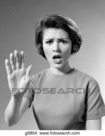 Picture - 1960S Alarmed Woman Holding Up Her Hand To Stop Something. Fotosearch