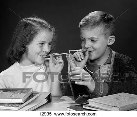 1960S Boy And Girl Sharing Single Bottle Of Soda With Two Straws At Table With Books Inside View Large Photo Image Stock Photography - 1960S Boy And Girl Sharing Single Bottle Of Soda With Two Straws At Table With Books Inside. Fotosearch