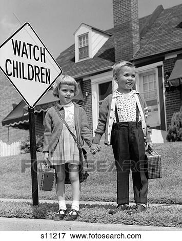 1960S Boy & Girl Dressed Up For School Carrying Plaid Lunchboxes Holding Hands Standing By Watch Children Sign View Large Photo Image Stock Photo - 1960S Boy & Girl Dressed Up For School Carrying Plaid Lunchboxes Holding Hands Standing By Watch Children Sign. Fotosearch