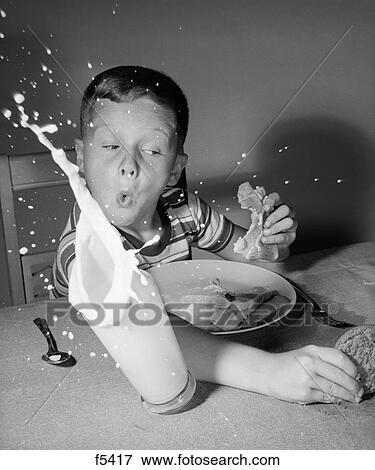 1960S Boy Having Lunch Knocking Over Milk Reaching For Cookie Surprise Splash Indoor View Large Photo Image Stock Photo - 1960S Boy Having Lunch Knocking Over Milk Reaching For Cookie Surprise Splash Indoor. Fotosearch
