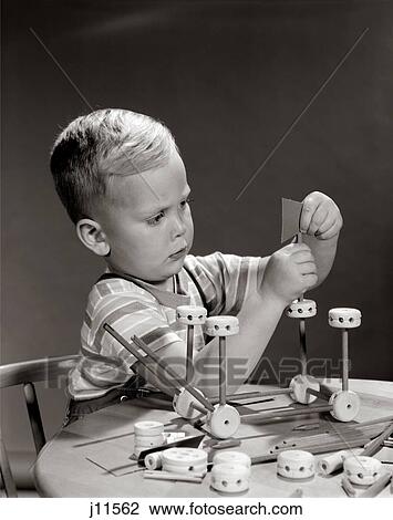 Stock Image - 1960S Boy Seated At Table Playing With Tinker Toy Construction Set. Fotosearch