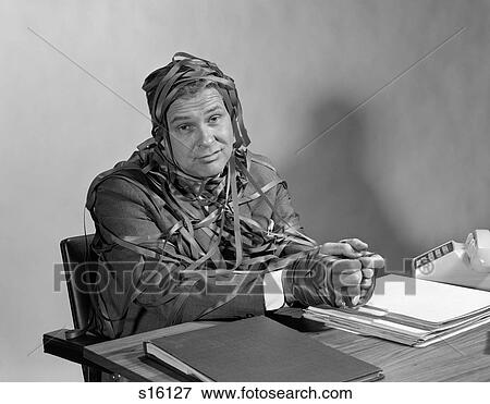 1960S Businessman At Desk Hands And Torso Wrapped In Typewriter Ribbon Red Tape Looking At Camera View Large Photo Image Stock Photo - 1960S Businessman At Desk Hands And Torso Wrapped In Typewriter Ribbon Red Tape Looking At Camera. Fotosearch