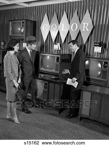 Stock Image - 1960S Couple In Department Store With Color Tv Salesman. Fotosearch