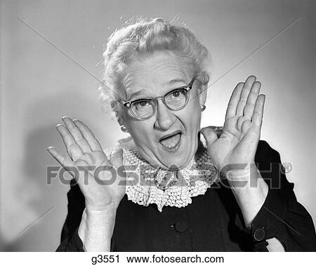 1960S Elderly Woman In Granny Glasses Holding Hand Up Near Face With Mouth Open Looking At Camera View Large Photo Image Stock Image - 1960S Elderly Woman In Granny Glasses Holding Hand Up Near Face With Mouth Open Looking At Camera. Fotosearch