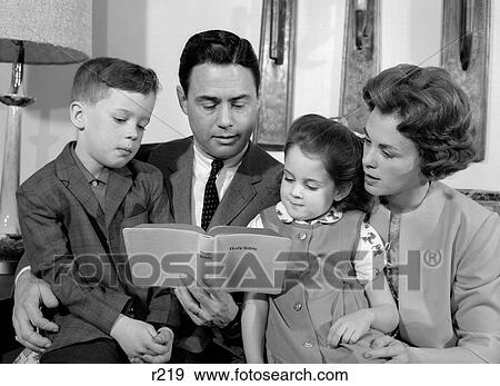 Stock Photo - 1960S Family Mother Father Son Daughter Sitting Together Reading Bible Indoor. Fotosearch