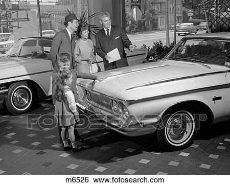 1960S Family Of 4 In Auto Showroom With Salesman Looking At White Plymouth View Large Photo Image Stock Photograph - 1960S Family Of 4 In Auto Showroom With Salesman Looking At White Plymouth. Fotosearch