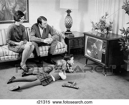 1960S Family Of 4 Watching Television In Living Room Parents On Couch Kids Lying On Floor View Large Photo Image Stock Photography - 1960S Family Of 4 Watching Television In Living Room Parents On Couch Kids Lying On Floor. Fotosearch