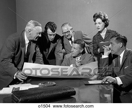 Picture - 1960S Group Of 5 Executives Gathered Around Table With Secretary Taking Notes & Plans Spread Out Between Them. Fotosearch