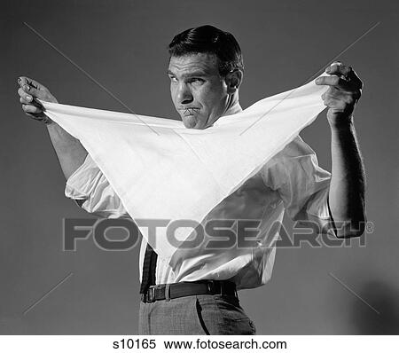 Stock Photography - 1960S Man Holding Cloth Diaper Folded In Triangle Under Chin With Safety Pins In Mouth Looking At Camera Angrily. Fotosearch
