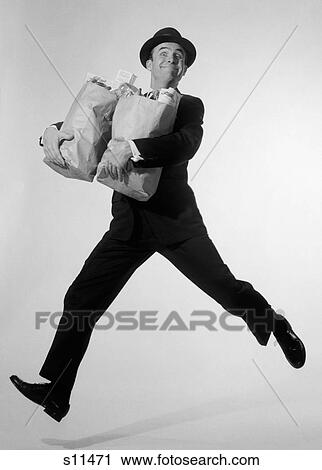 1960S Man In Suit & Fedora Leaping Forward With Grocery Bags In Arms Looking At Camera View Large Photo Image Stock Image - 1960S Man In Suit & Fedora Leaping Forward With Grocery Bags In Arms Looking At Camera. Fotosearch