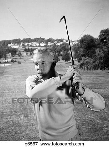 1960S Man Playing Golf Hitting Golf Ball From Fairway With Iron Club View Large Photo Image Stock Photo - 1960S Man Playing Golf Hitting Golf Ball From Fairway With Iron Club. Fotosearch