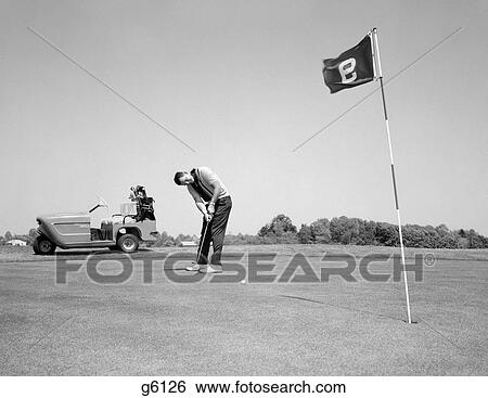 1960S Man Playing Golf Putting Golf Ball Towards Flag And Cup Hole On 9Th Green Spring Summer Outdoor View Large Photo Image Stock Photograph - 1960S Man Playing Golf Putting Golf Ball Towards Flag And Cup Hole On 9Th Green Spring Summer Outdoor. Fotosearch