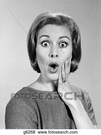 Stock Photo - 1960S Portrait Woman With Hand On Cheek Looking At Camera With Shocked Expression. Fotosearch