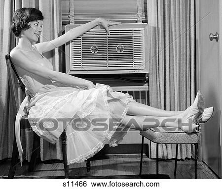 1960S Side View Of Woman In Gingham Dress Propping Legs Up On Stool Putting Hand On Top Of Air Conditioner View Large Photo Image Stock Photograph - 1960S Side View Of Woman In Gingham Dress Propping Legs Up On Stool Putting Hand On Top Of Air Conditioner. Fotosearch