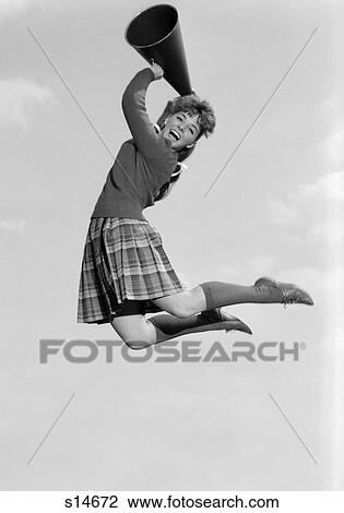 1960S Teenage Girl Cheerleader Cheering Jumping Into The Air Holding Megaphone Looking At Camera View Large Photo Image Stock Image - 1960S Teenage Girl Cheerleader Cheering Jumping Into The Air Holding Megaphone Looking At Camera. Fotosearch