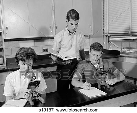 Stock Photo - 1960S Three Students Using Microscopes Two Boys One Girl Indoor High School. Fotosearch