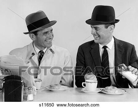 1960S Two Businessmen Wearing Hats Drinking Coffee Smiling Talking Sitting Together At A Diner Lunch Counter View Large Photo Image Stock Image - 1960S Two Businessmen Wearing Hats Drinking Coffee Smiling Talking Sitting Together At A Diner Lunch Counter . Fotosearch