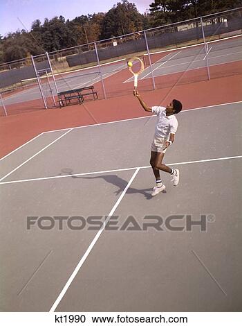 1970S Man African-American Tennis Player Hitting Ball Overhead With Racket View Large Photo Image Stock Image - 1970S Man African-American Tennis Player Hitting Ball Overhead With Racket . Fotosearch