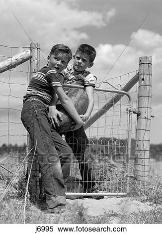 1970S Two Farm Boys In Striped T-Shirts And Blue Jeans Stealing Large Watermelon From A Garden View Large Photo Image Stock Photography - 1970S Two Farm Boys In Striped T-Shirts And Blue Jeans Stealing Large Watermelon From A Garden. Fotosearch