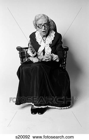 1970S Woman Grandmother In Old Fashioned Dress Sitting Rocking Chair Knitting Surprised Facial Expression Looking At Camera View Large Photo Image Stock Image - 1970S Woman Grandmother In Old Fashioned Dress Sitting Rocking Chair Knitting Surprised Facial Expression Looking At Camera. Fotosearch