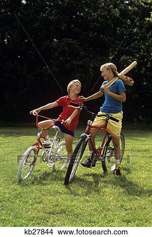 1980S 1990S Juvenile Boy And Teenage Boy On Bicycles With Baseball Bat And Glove View Large Photo Image Picture - 1980S 1990S Juvenile Boy And Teenage Boy On Bicycles With Baseball Bat And Glove. Fotosearch