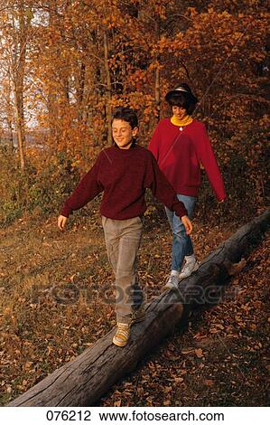 1980S Brother And Sister Walking AcrossLog In Woods In Autumn View Large Photo Image Stock Image - 1980S Brother And Sister Walking AcrossLog In Woods In Autumn. Fotosearch