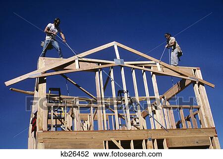 Stock Image - 1980S Building A New House With Lumber Raising The A-Frame For The Roof Line. Fotosearch