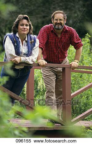 1980S Couple Smiling Leaning On Wooden Bridge In Garden Looking At Camera View Large Photo Image Stock Photography - 1980S Couple Smiling Leaning On Wooden Bridge In Garden Looking At Camera. Fotosearch