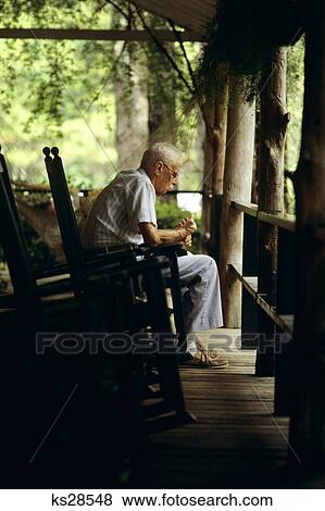 Stock Photo - 1980S Elderly Senior Man Sitting On Porch In Rocking Chair. Fotosearch