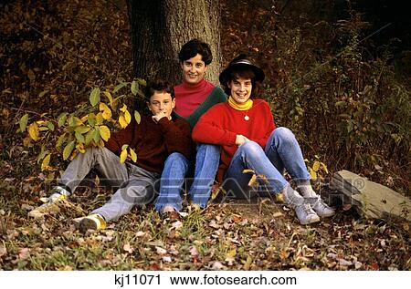 1980S Family Mother Son And Daughter Sitting At Base Of Tree In Woods Autumn View Large Photo Image Stock Image - 1980S Family Mother Son And Daughter Sitting At Base Of Tree In Woods Autumn . Fotosearch