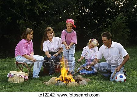 1990S Family Roasting Hot Dogs On Sticks Over Campfire View Large Photo Image Stock Image - 1990S Family Roasting Hot Dogs On Sticks Over Campfire. Fotosearch