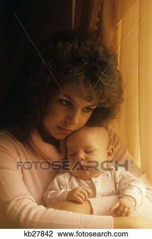 Stock Image - 1990S Woman Holding Sleeping Baby. Fotosearch