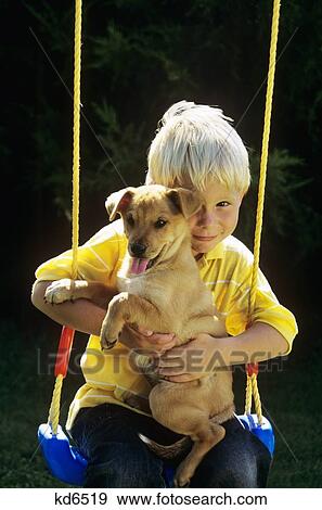 Stock Photo - Boy Sitting On Swing With Puppy . Fotosearch