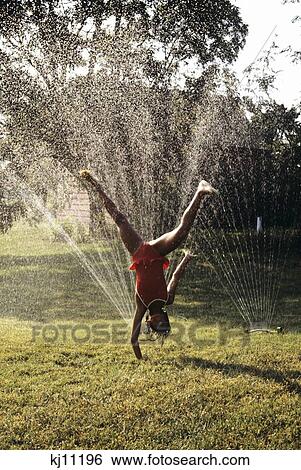 Little Girl Cartwheeling Through Lawn Sprinkler View Large Photo Image Stock Photograph - Little Girl Cartwheeling Through Lawn Sprinkler . Fotosearch