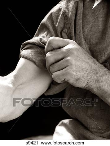 Stock Image - 1920S 1930S 1940S 1950S Man Rolling Up Sleeve Symbolic Get To Work. Fotosearch