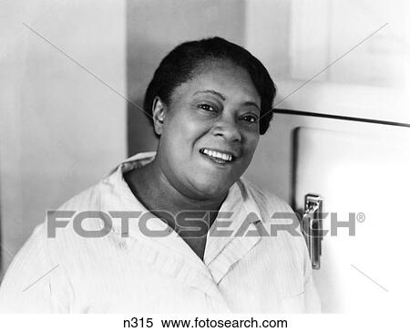 1930S 1940S Portrait Smiling African American Woman Domestic By Refrigerator In Kitchen Looking At Camera View Large Photo Image Stock Photography - 1930S 1940S Portrait Smiling African American Woman Domestic By Refrigerator In Kitchen Looking At Camera. Fotosearch