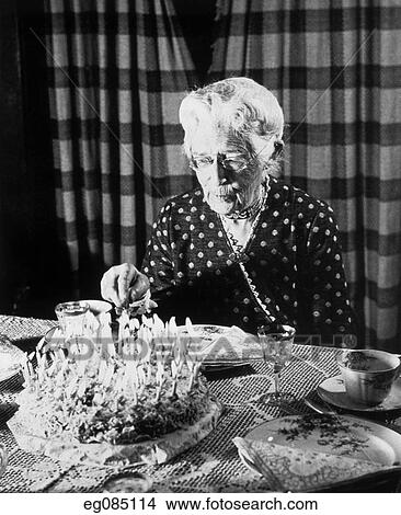 Picture -  1940S 1950S Elderly Senior Woman About To Cut Birthday Cake Covered In Candles. Fotosearch