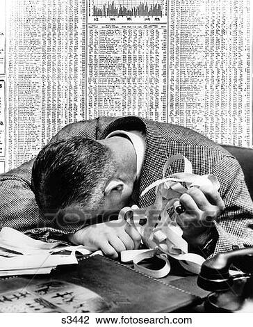 1940S Man Head On Desk Holding Stock Ticker Tape With Newspaper Stock Page Behind Him View Large Photo Image Stock Image - 1940S Man Head On Desk Holding Stock Ticker Tape With Newspaper Stock Page Behind Him. Fotosearch