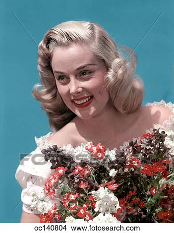1940S Portrait Smiling Blond Teen Girl Wearing Off The Shoulder Lace Blouse Holding Bouquet Of Spring Flowers View Large Photo Image Picture - 1940S Portrait Smiling Blond Teen Girl Wearing Off The Shoulder Lace Blouse Holding Bouquet Of Spring Flowers. Fotosearch