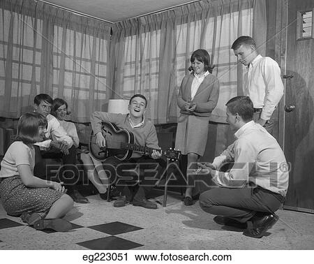 1950S 1960S Group Of Young Teenagers Gathering Around Boy Playing Guitar View Large Photo Image Stock Image - 1950S 1960S Group Of Young Teenagers Gathering Around Boy Playing Guitar. Fotosearch