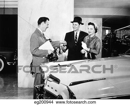 1950S Couple Buying New Car From Automobile Salesman Handing Over The Keys View Large Photo Image Picture - 1950S Couple Buying New Car From Automobile Salesman Handing Over The Keys. Fotosearch