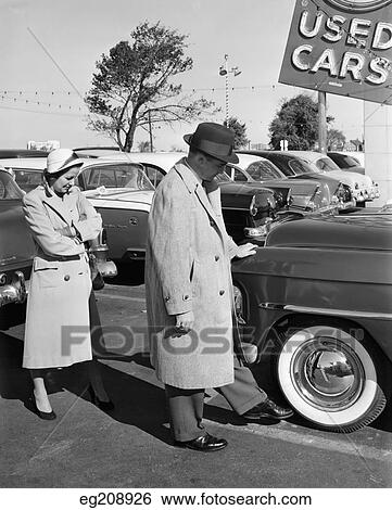 1950S Couple In Used Car Lot Man Kicking Tire View Large Photo Image Stock Photograph - 1950S Couple In Used Car Lot Man Kicking Tire. Fotosearch